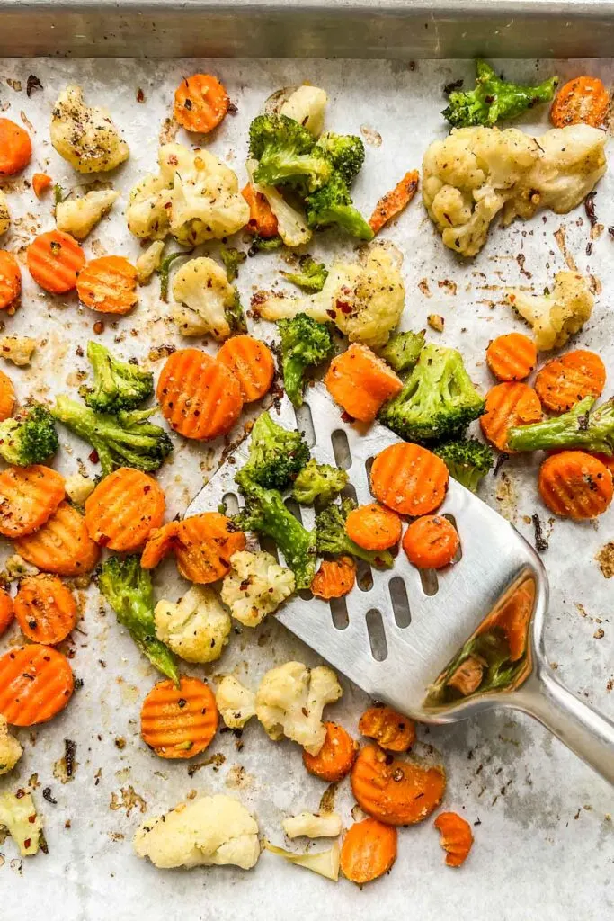 A spatula scooping roasted California mix veggies.