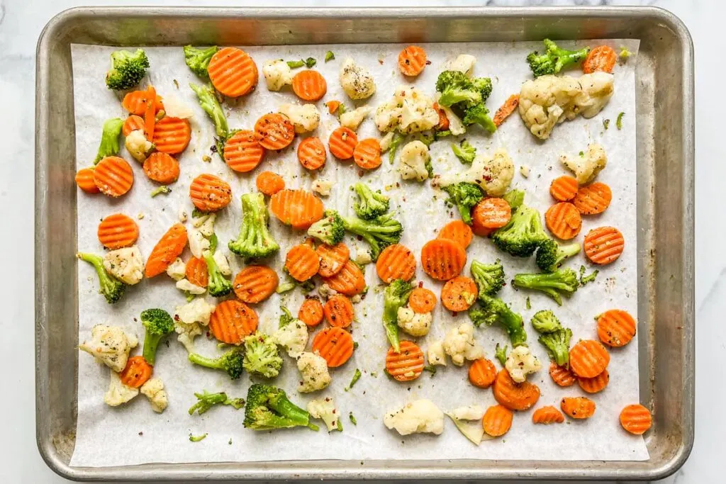 Roasting California vegetables with olive oil and spices on a sheet pan.