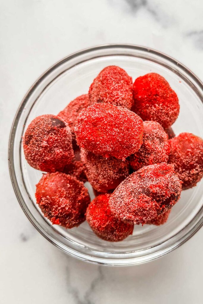 Sour candy frozen grapes in a glass bowl.