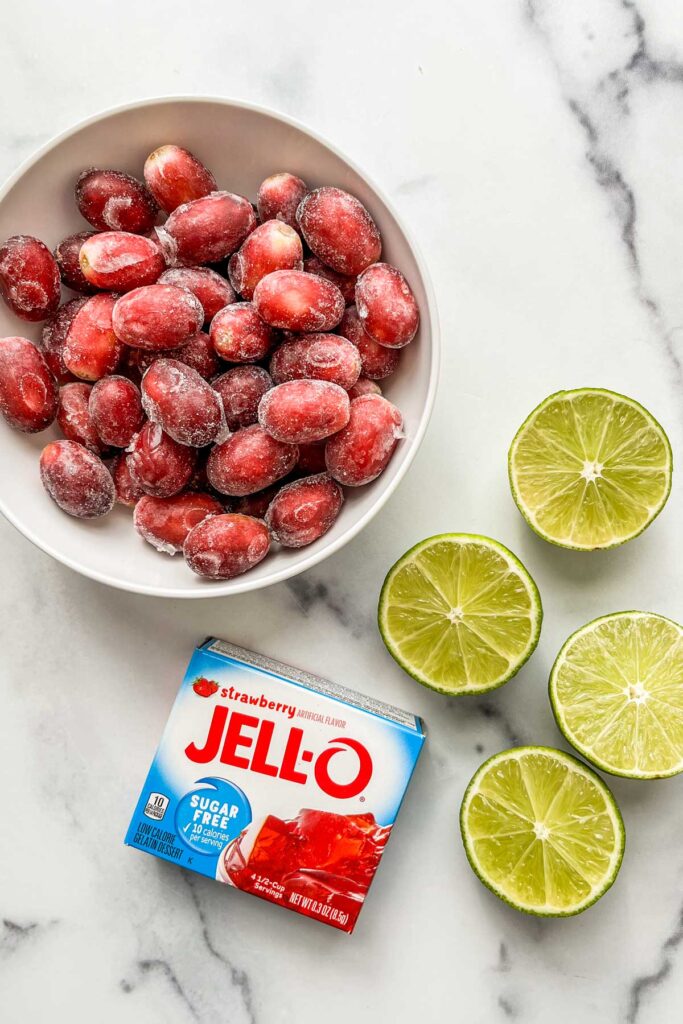 Frozen grapes, sliced limes, and a box of strawberry Jell-o.