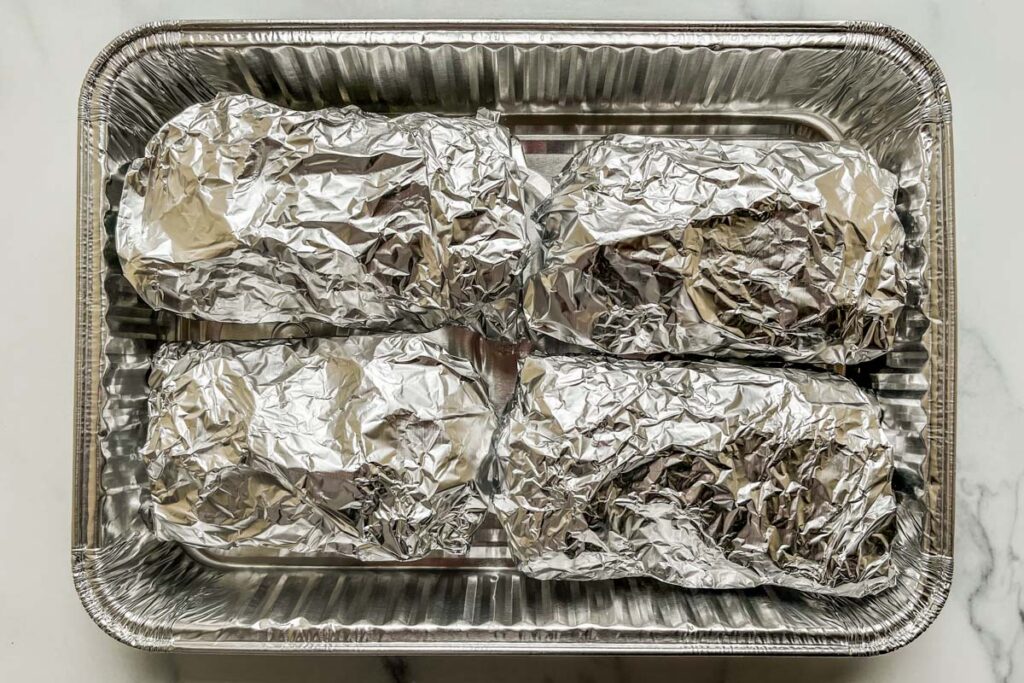 Breakfast burritos wrapped in aluminum foil.