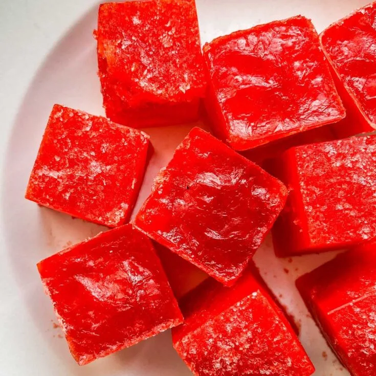 Frozen jello pieces on a white plate.