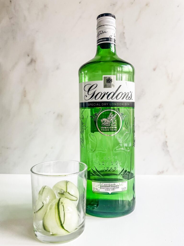 Cucumber Ice Cubes in Glass next to bottle of gin